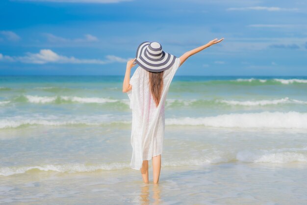 Retrato hermosa joven asiática relajarse sonrisa alrededor de la playa mar océano en viaje de vacaciones vacaciones