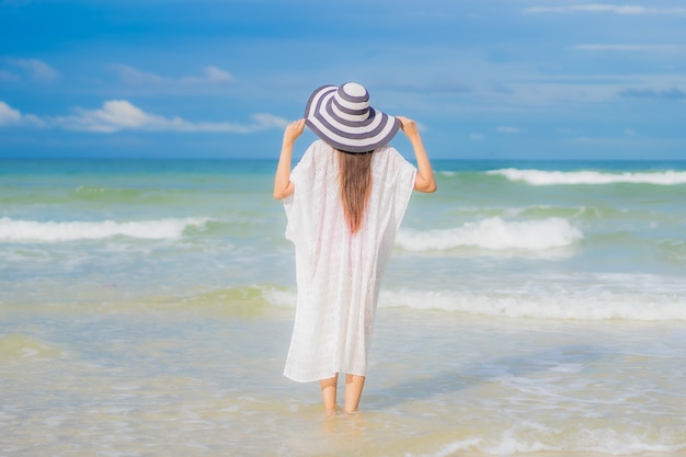 Retrato hermosa joven asiática relajarse sonrisa alrededor de la playa mar océano en viaje de vacaciones vacaciones