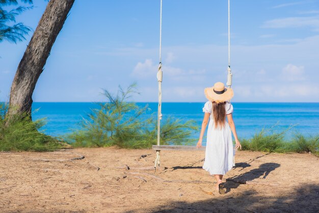 Retrato hermosa joven asiática relajarse sonrisa en columpio alrededor de la playa mar océano para viajes por la naturaleza en vacaciones