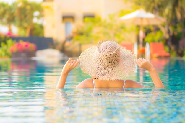 Retrato hermosa joven asiática relajarse sonrisa disfrutar de ocio alrededor de la piscina en el hotel resort de vacaciones
