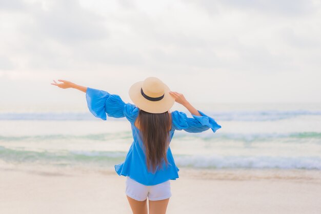 Foto gratuita retrato hermosa joven asiática relajarse sonrisa de ocio alrededor de la playa mar océano al atardecer