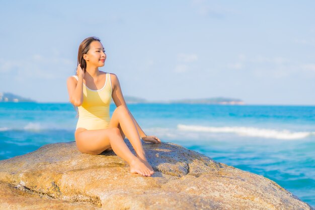 Retrato hermosa joven asiática relajarse sonrisa ocio alrededor de la playa mar océano en viaje viaje de vacaciones