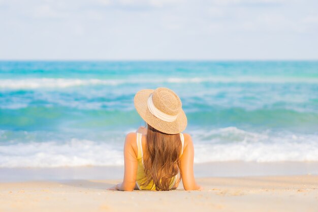 Retrato hermosa joven asiática relajarse sonrisa ocio alrededor de la playa mar océano en viaje viaje de vacaciones