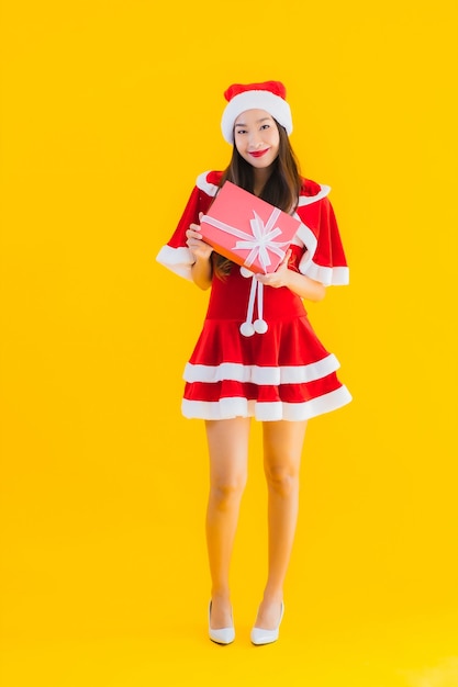 Retrato hermosa joven asiática ropa de navidad y sombrero sonríen feliz con caja de regalo roja