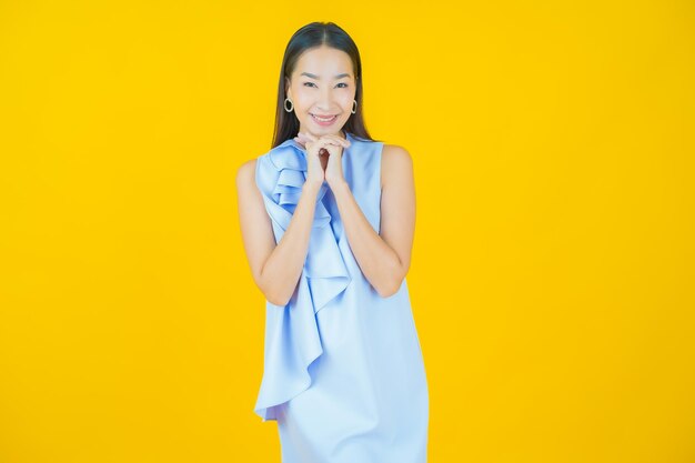 Retrato hermosa joven asiática sonriendo en amarillo