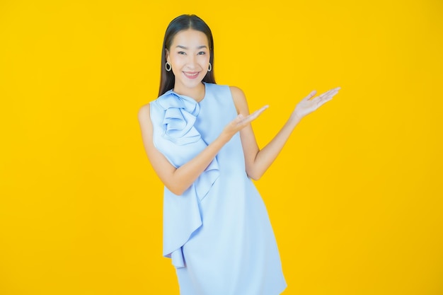 Retrato hermosa joven asiática sonriendo en amarillo