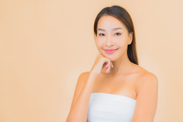Retrato hermosa joven asiática en spa con maquillaje natural en beige