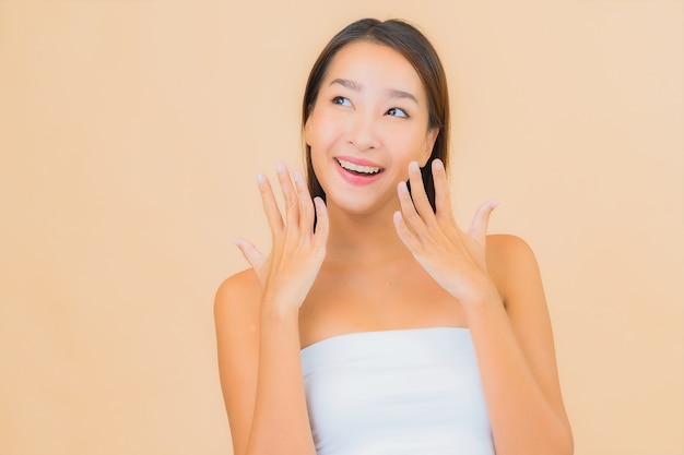 Retrato hermosa joven asiática en spa con maquillaje natural en beige