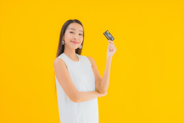 Retrato hermosa joven asiática con tarjeta de crédito para compras en línea
