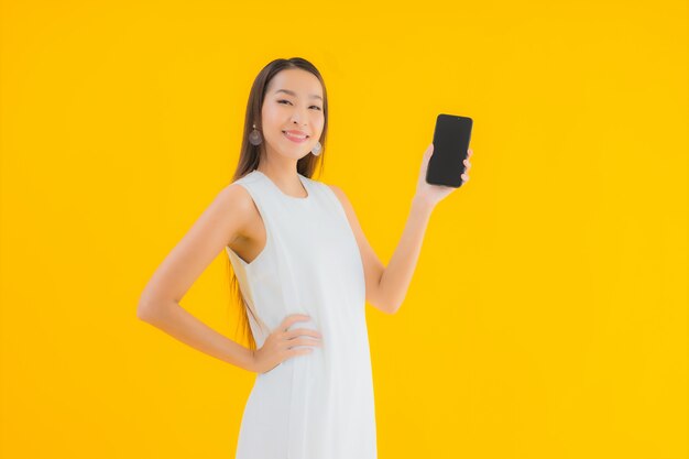 Retrato hermosa joven asiática con teléfono móvil inteligente