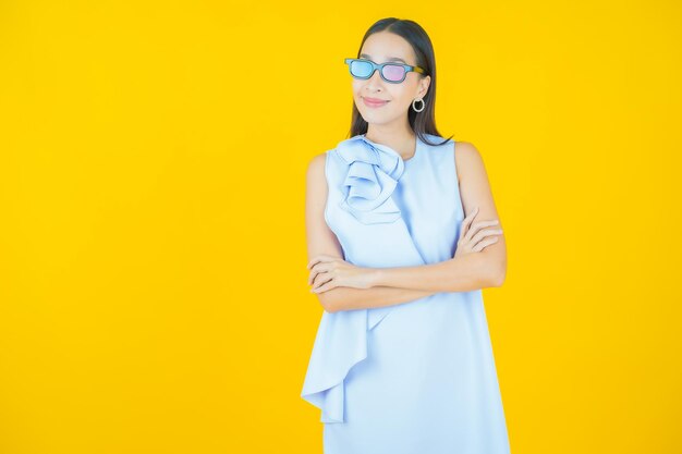 Retrato hermosa joven asiática usar anteojos 3d en amarillo