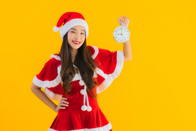 Retrato hermosa joven asiática usar ropa de navidad y reloj de demostración de sombrero