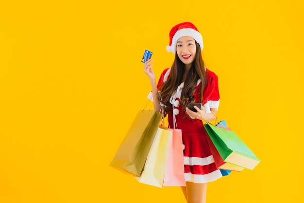Retrato hermosa joven asiática usar sombrero de ropa de Navidad con una gran cantidad de bolsa de compras