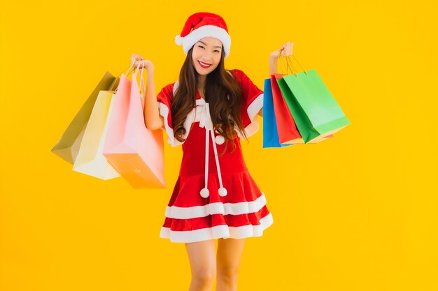 Retrato hermosa joven asiática usar sombrero de ropa de Navidad con una gran cantidad de bolsa de compras