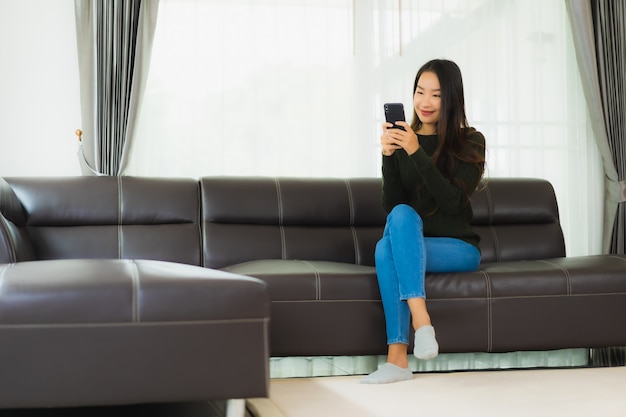 Retrato hermosa joven asiática usar teléfono móvil inteligente o teléfono móvil