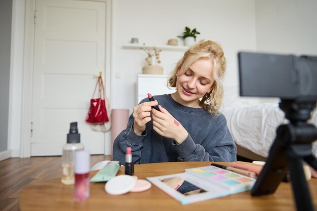 Foto gratuita retrato de una hermosa joven creadora de contenido para redes sociales sentada frente a la digital