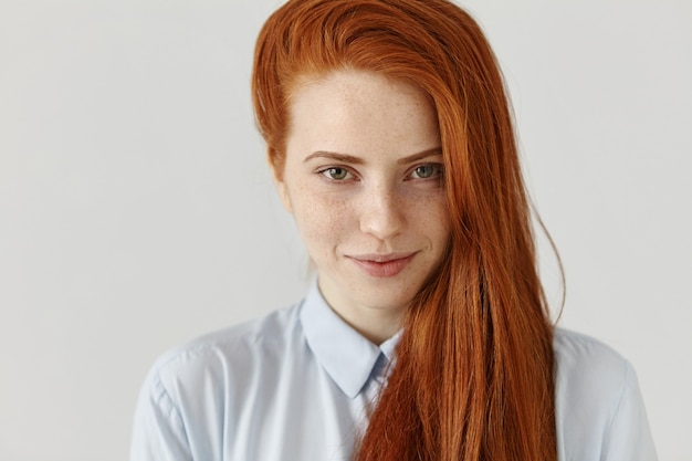 Retrato de hermosa joven estudiante europea con pecas con su largo cabello pelirrojo