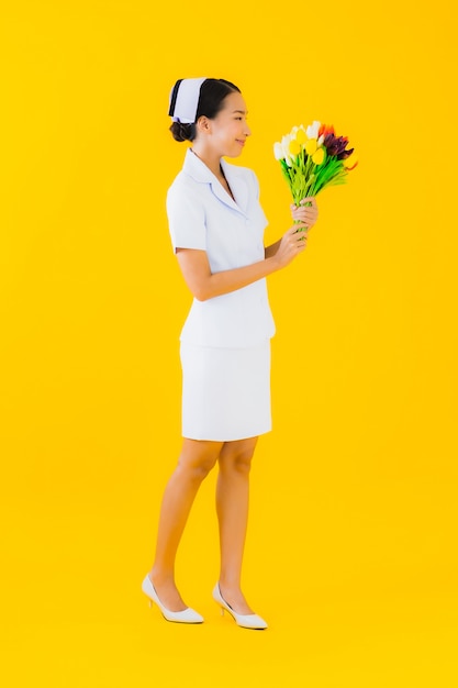 Retrato hermosa joven mujer asiática enfermera tailandesa con flor