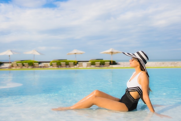 Retrato hermosa joven mujer asiática feliz sonrisa relajarse en la piscina