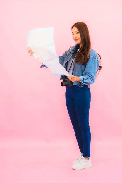 Retrato hermosa joven mujer asiática mochila o equipaje con cámara lista para viajar en vacaciones en pared rosa