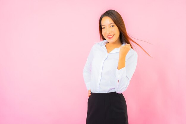 Retrato hermosa joven mujer asiática de negocios con acción rosa pared aislada