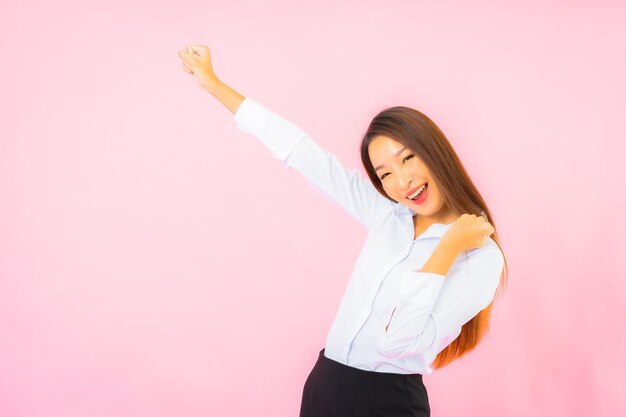 Retrato hermosa joven mujer asiática de negocios con acción rosa pared aislada