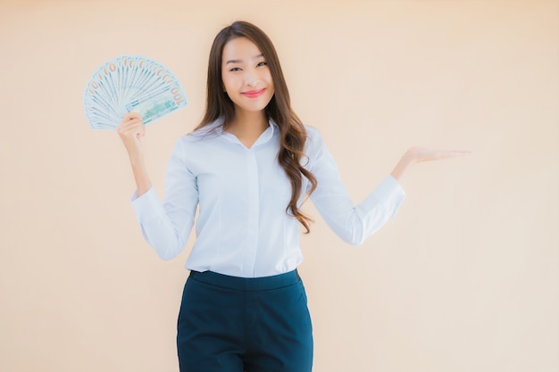 Retrato hermosa joven mujer asiática de negocios con dinero en efectivo o dinero