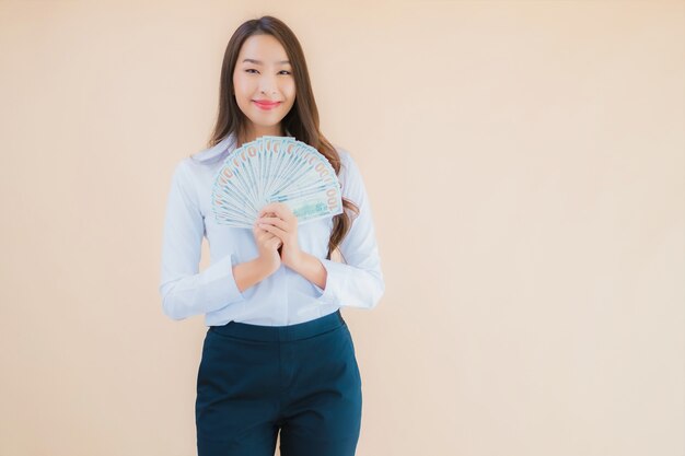 Retrato hermosa joven mujer asiática de negocios con dinero en efectivo o dinero