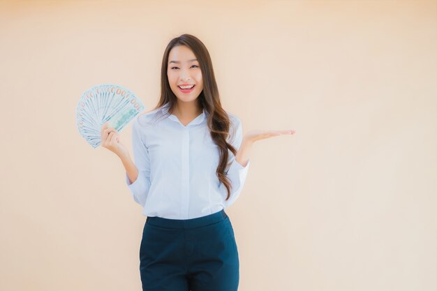 Retrato hermosa joven mujer asiática de negocios con dinero en efectivo o dinero