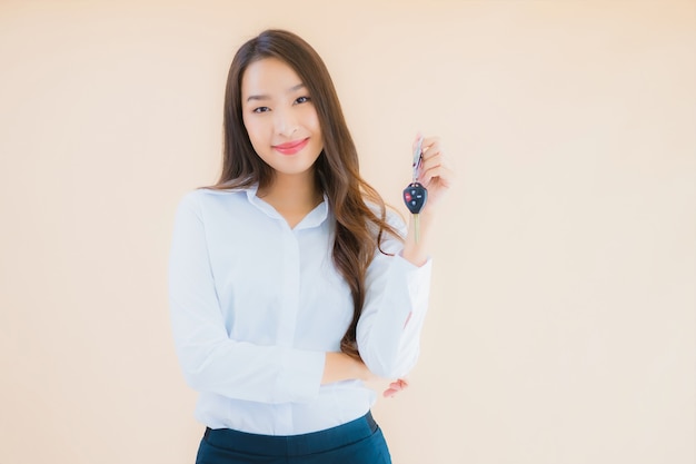 Foto gratuita retrato hermosa joven mujer asiática de negocios con llave de coche