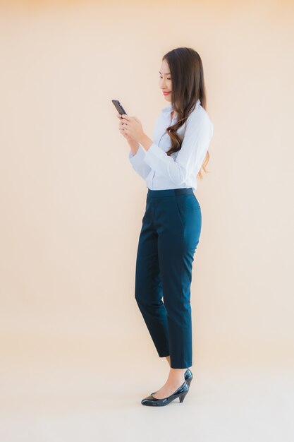 Retrato hermosa joven mujer asiática de negocios con teléfono móvil inteligente y taza de café