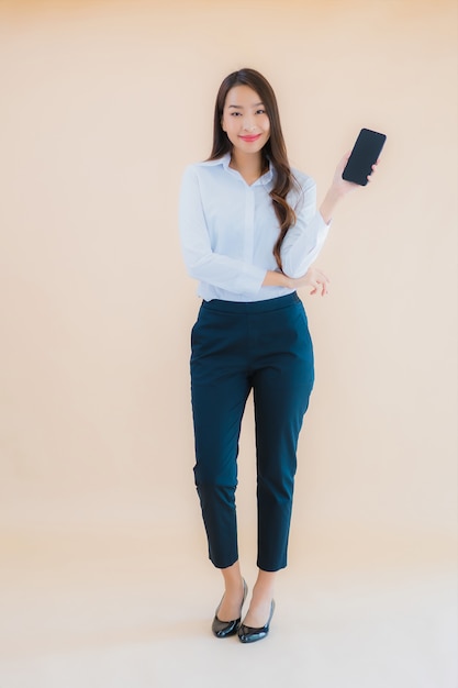 Retrato hermosa joven mujer asiática de negocios con teléfono móvil inteligente y taza de café