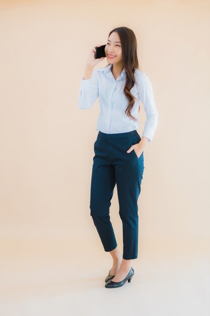 Retrato hermosa joven mujer asiática de negocios con teléfono móvil inteligente y taza de café