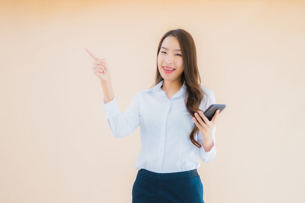Retrato hermosa joven mujer asiática de negocios con teléfono móvil inteligente y taza de café