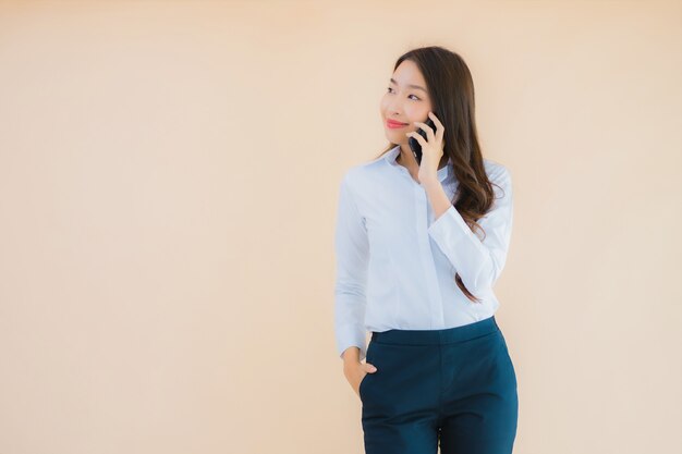 Retrato hermosa joven mujer asiática de negocios con teléfono móvil inteligente y taza de café