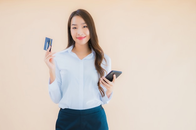 Retrato hermosa joven mujer asiática de negocios con teléfono y tarjeta de crédito