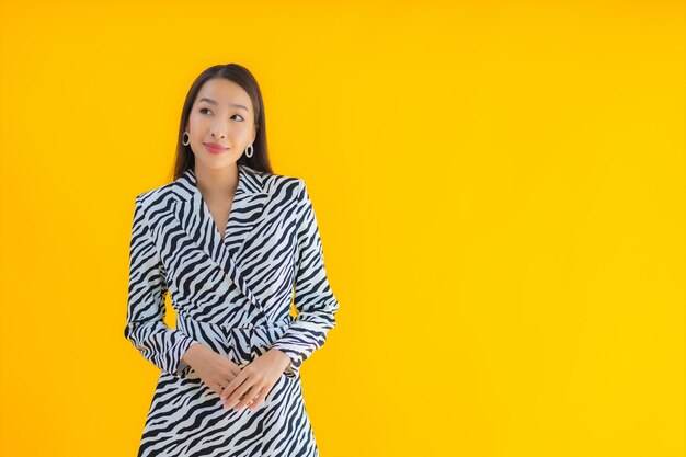 Retrato hermosa joven mujer asiática sonrisa feliz con acción en amarillo