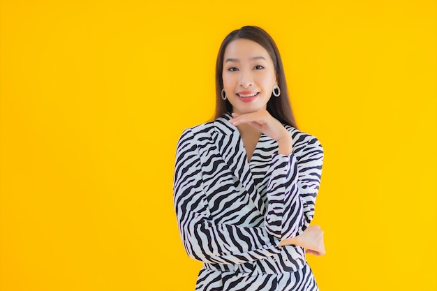 Retrato hermosa joven mujer asiática sonrisa feliz con acción en amarillo