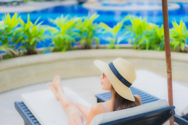 Retrato hermosa joven mujer asiática sonrisa feliz relajarse alrededor de la piscina al aire libre