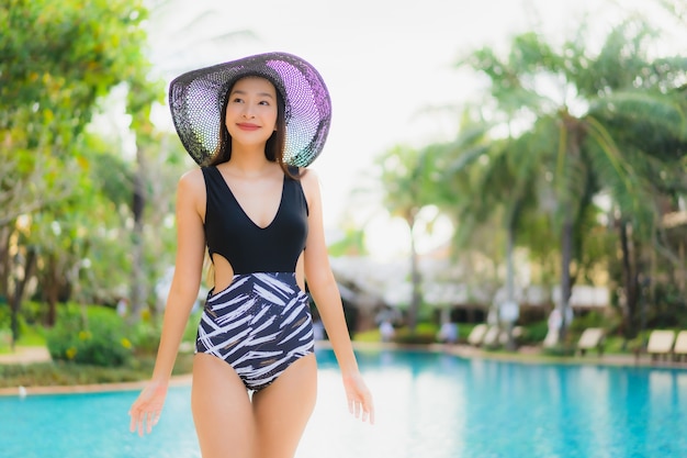 Retrato hermosa joven mujer asiática sonrisa feliz relajarse alrededor de la piscina