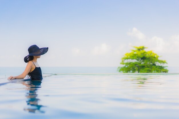 Retrato hermosa joven mujer asiática sonrisa feliz relajarse piscina al aire libre en el hotel