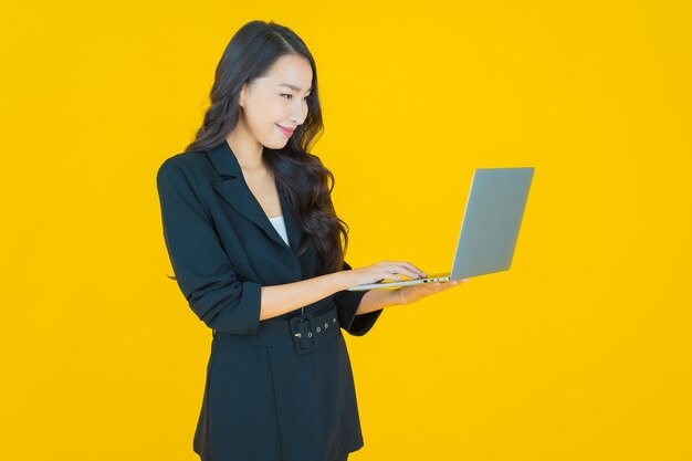 Retrato hermosa joven mujer asiática sonrisa con ordenador portátil sobre fondo aislado