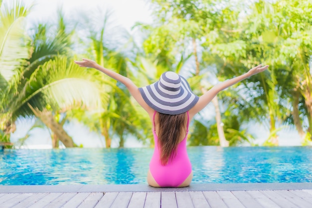 Foto gratuita retrato hermosa joven mujer asiática sonrisa relajarse alrededor de la piscina al aire libre en el hotel resort en viaje de vacaciones de vacaciones