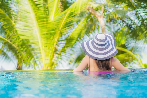 Retrato hermosa joven mujer asiática sonrisa relajarse alrededor de la piscina al aire libre en el hotel resort en viaje de vacaciones de vacaciones