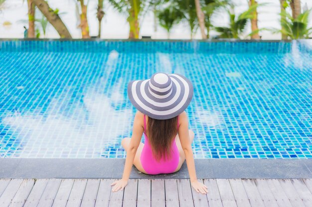 Retrato hermosa joven mujer asiática sonrisa relajarse alrededor de la piscina al aire libre en el hotel resort en viaje de vacaciones de vacaciones