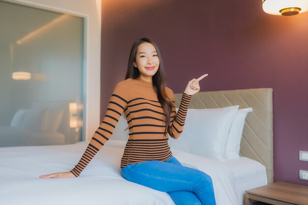 Retrato hermosa joven mujer asiática sonrisa relajarse en la cama