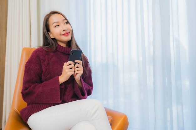 Retrato hermosa joven mujer asiática sonrisa relajarse en el sofá en el interior de la sala de estar