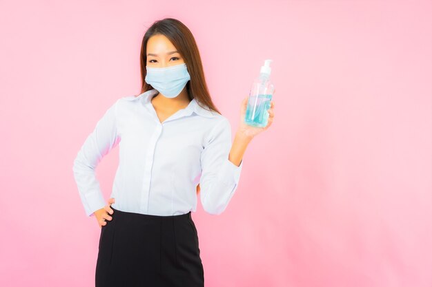 Retrato hermosa joven mujer asiática usa máscara para protegerse de covid19 y coronavirus en la pared rosa