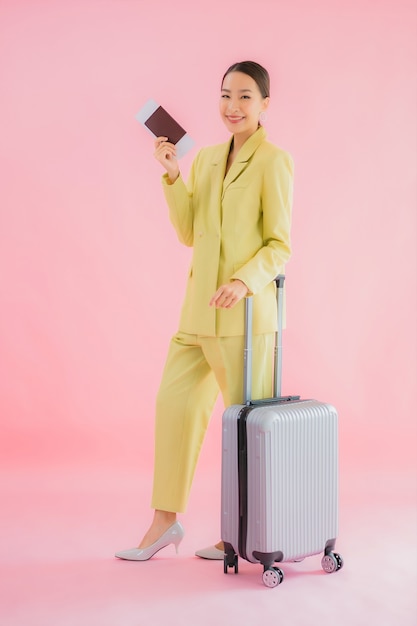 Retrato hermosa joven mujer de negocios asiática con bolsa de equipaje y pasaporte en color