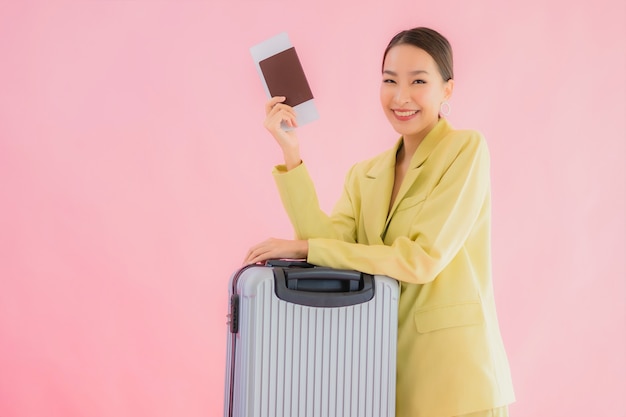 Retrato hermosa joven mujer de negocios asiática con bolsa de equipaje y pasaporte en color